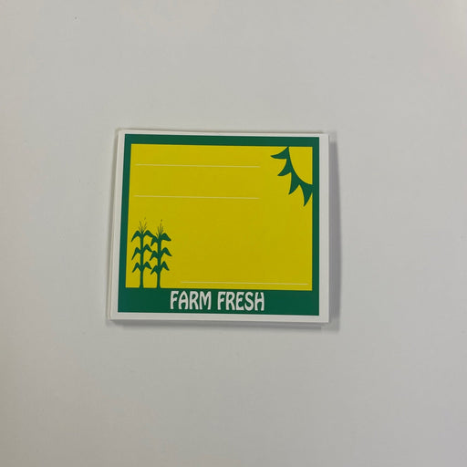 A yellow and green mini shelf sign with the text 'Farm Fresh' printed on it, designed for retail sale of produce.