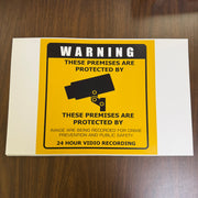 Warning sign on a white card with yellow border, placed on a wooden surface.