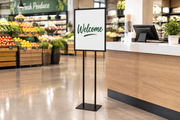Black bulletin floor sign holder beside a supermarket service counter