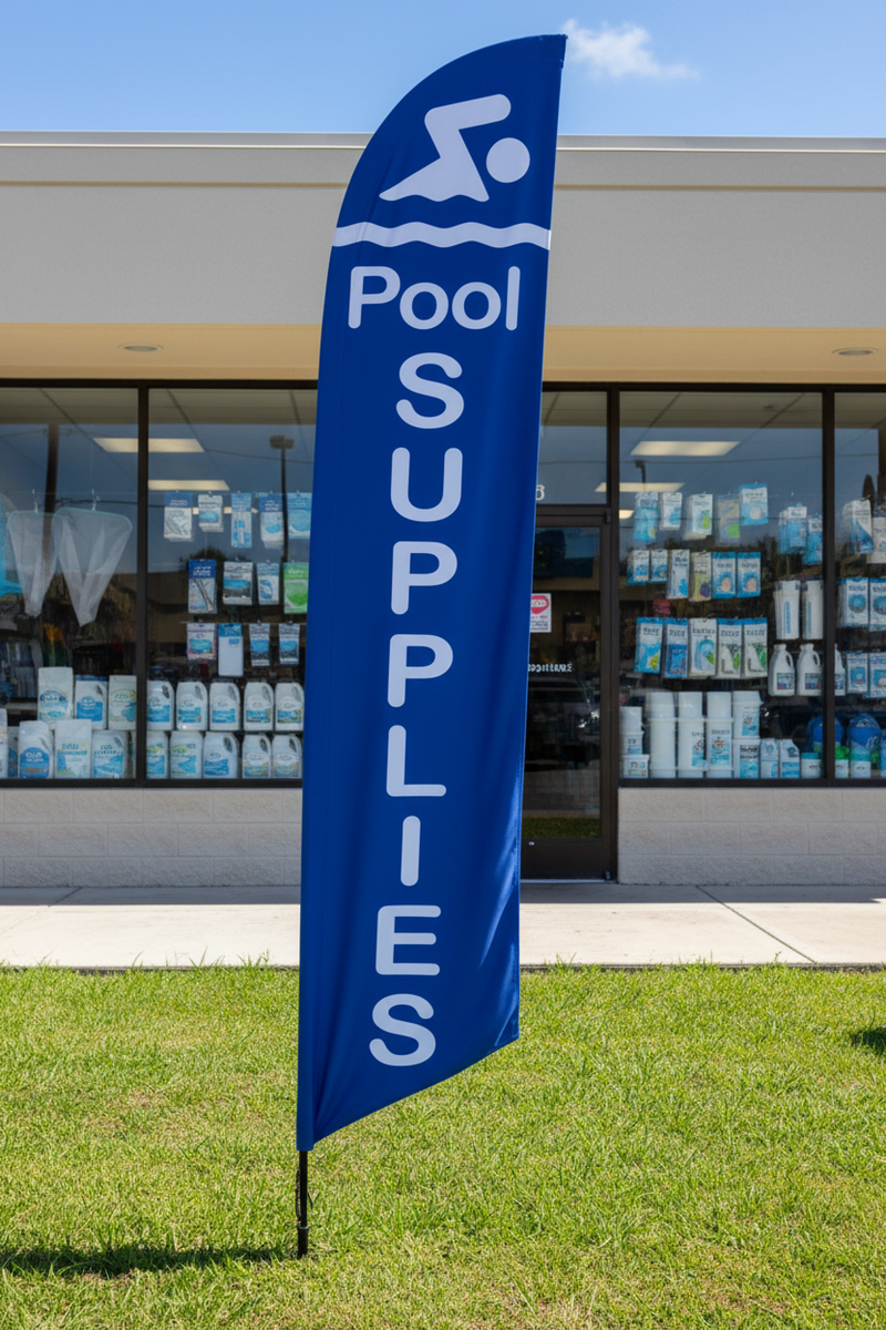 Blue Pool Supplies feather flag planted in grass in front of a pool supply store – 16' tall outdoor display – Screen Gems Inc.