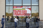 IGA Truckload Deals vinyl banner 5 feet wide hung on an IGA supermarket window or entrance announcing a truckload sale event with shoppers and carts