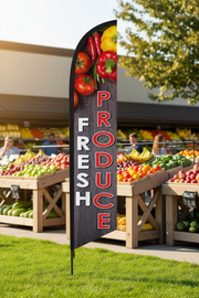 Fresh Produce feather flag planted in grass outside a grocery store or farmers market with outdoor produce displays in background – Screen Gems Inc.