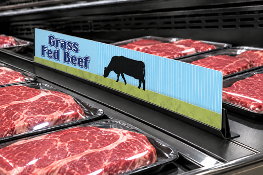 Illustrative Grass Fed Beef 24-inch meat case divider with a visibly thin printed sign panel in a low-profile black holder among meat trays