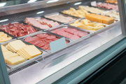 Clear 24 in easel sign holder runner inside a deli case holding a single price card in front of sliced meats and cheeses
