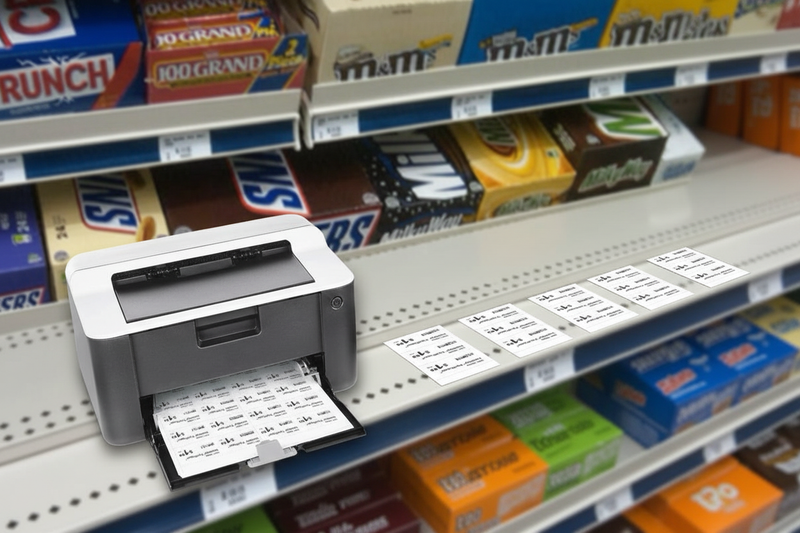 Printable perforated paper price tags displayed in a retail shelf price channel beside a printer, lifestyle merchandising view