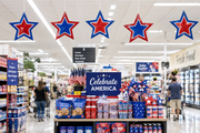 Patriotic Star ceiling danglers hanging above a seasonal grocery store aisle display