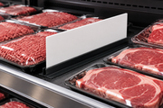 Illustrative blank custom meat case divider panel in a holder separating meat display sections in a supermarket case