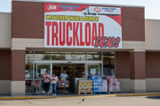 IGA Truckload Deals vinyl banner 8 feet wide hung on an IGA supermarket storefront announcing a truckload sale event with shoppers and merchandise