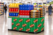 Football Corrugated Base Pallet Wrap, 42 in x 25 ft, green field and football print wrapping a supermarket game day pallet display of chips, soda cases and party snack trays