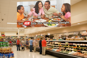 IGA Help with Dinner vinyl banner Design B hung above a deli section inside an IGA supermarket with shoppers browsing prepared foods