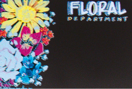 A price sign with a floral department theme, featuring a sunflower and various colored flowers on a black background with the text 'Floral Department'.