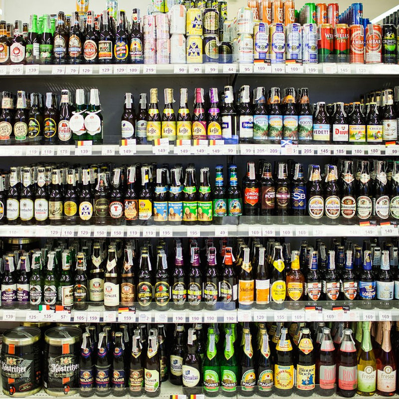 Shelves in a liquor store filled with various bottles of alcohol, with price tags attached.